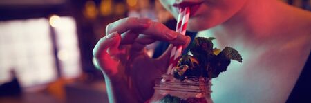 Modern woman having cocktail in bar