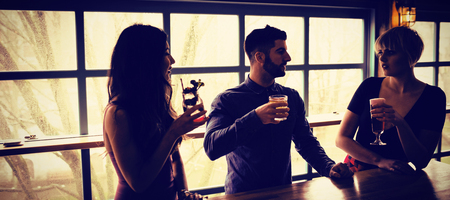 Three friends enjoying the drinks in barの写真素材