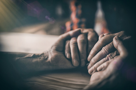 Close-up of senior couple holding hands at homeの写真素材
