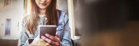 Beautiful young woman using smartphone at coffee shopの写真素材