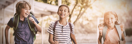 Happy school kids running in corridor at school