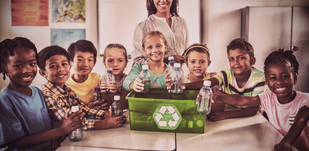 Portrait of pupils and teacher recycling in classroomの写真素材