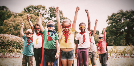 Children wearing superhero costume standing in the parkの写真素材