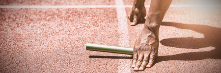 Hands of athlete holding baton on running trackの写真素材