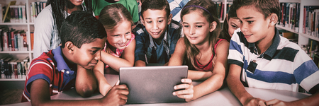 Front view of pupils using tablet pc in library