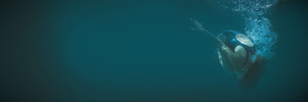 Athletic swimmer doing a somersault underwater in the swimming pool at the leisure centreの写真素材