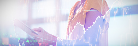 Stocks and shares against business executive using digital tablet