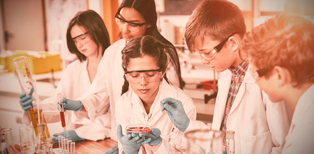 Attentive school kids doing a chemical experiment in laboratory at schoolの写真素材