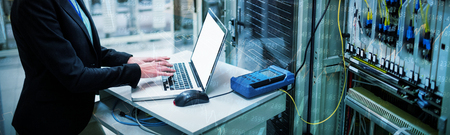 Stocks and shares against technician using laptop while analyzing server