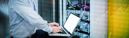 Stocks and shares against technician using laptop while analyzing server