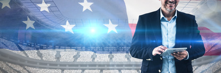 Portrait of businessman using tablet computer against close-up of an american flag