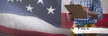 Mid-section of construction worker against close-up of an american flag. USA Labor Day Concept Advertisement. USA Labor Day Concept Advertisementの写真素材