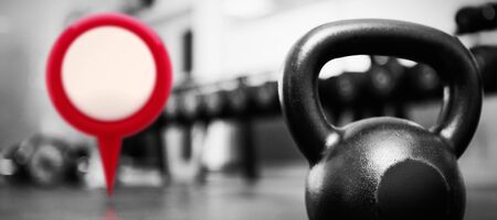 Close-up of red map location marker against kettlebell in gymの写真素材