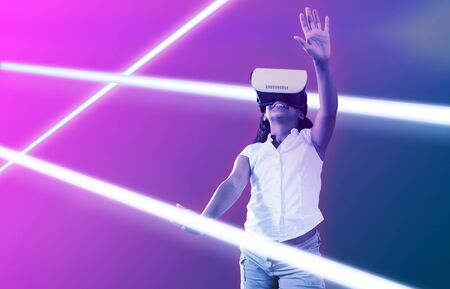 Girl wearing virtual reality simulator against gradient