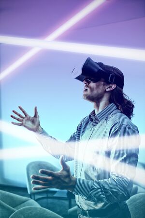 Turquoise and purple background against male executive using virtual reality headset in waiting area