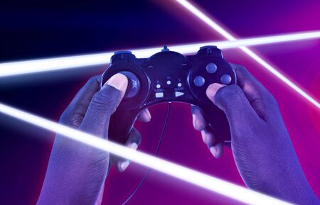 Hand of man playing video game against white background against turquoise and purple background