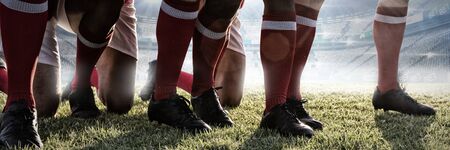 Male rugby players playing rugby in the ground against stadium against skyの写真素材
