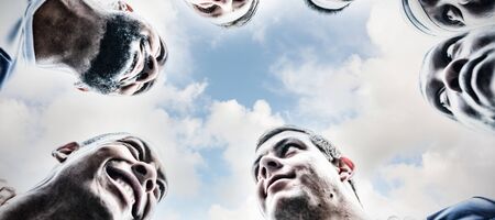 bottom view of group of male rugby players forming huddles in stadiumの写真素材