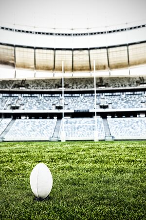Rugby ball on the pitch against rugby ball stand in a stadiumの写真素材