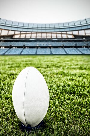 Rugby ball on the pitch against rugby stadium at dawnの写真素材
