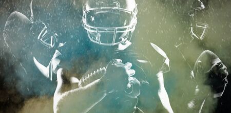 Rear view of American football player in helmet pointing upwardsの写真素材