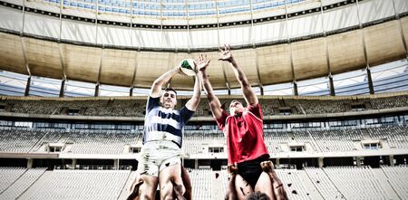 Rugby Players Playing Match against rugby goal post on a sunny day in the stadiumの写真素材