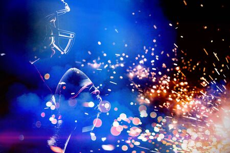 American Football Player against firework bursting sparkle backgroundの写真素材