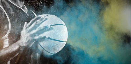 Basketball player against splashing of color powderの写真素材