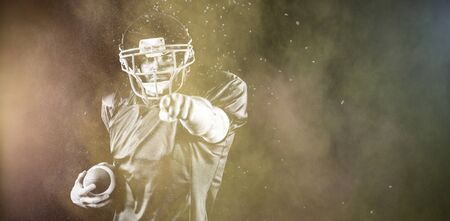 American Football Player against splashing of color powderの写真素材