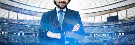Portrait of businessman standing with arms crossed against stocks and shares