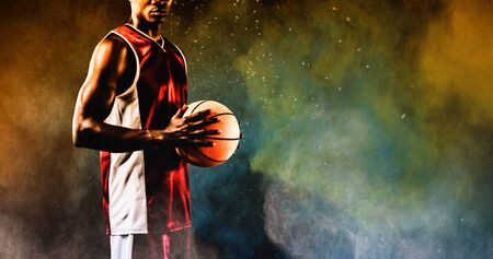 Basketball player against splashing of yellow color powderの写真素材