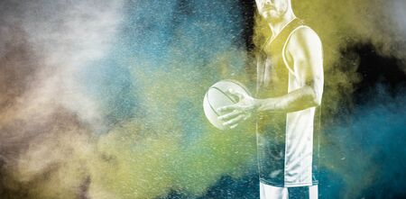 Basketball player against splashing of color powderの写真素材