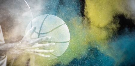 Tough female basketball player against splashing of color powderの写真素材