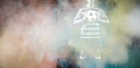 Focused Soccer Player against splashing of color powder