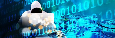 Hacker using white laptop at table against defocused lights against snow covered trees