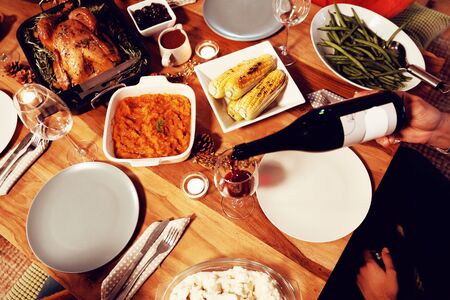 High angle view of a young mixed race man sitting at a table at home set for Thanksgiving dinner...