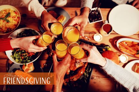 Happy Friendsgiving against millennial adult friends celebrating thanksgiving together at home の写真素材