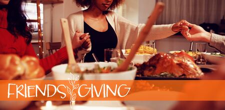Happy Friendsgiving against millennial adult friends celebrating thanksgiving together at home の写真素材
