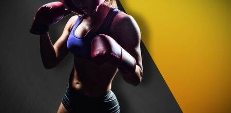 Portrait of female fighter with fighting stance against black metal textureの写真素材
