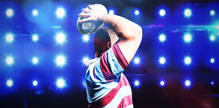 Rugby player against composite image of blue spotlightの写真素材