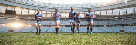 Rugby players against rugby stadium at dawnの写真素材