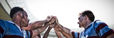 Rugby players against rugby stadium at dawn