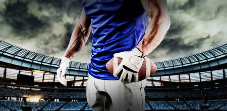 American football player against rugby stadium at dawnの写真素材