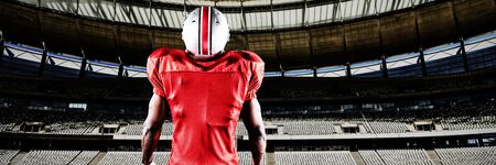 American football player against rugby goal post on a sunny day in the stadiumの写真素材