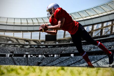 American Football Player against rugby goal post on a sunny day in the stadiumの写真素材