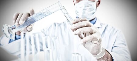 Doctor wearing medical gloves filling the test tube against white background. Testing for...