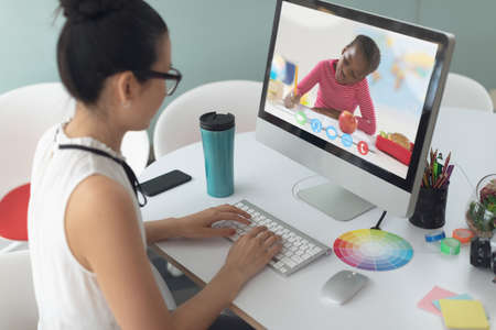 Caucasian female teacher using computer on video call with schoolboy learning from home. Online education staying at home in self isolation during quarantine lockdown.の写真素材