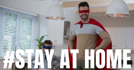 The words #Stay At Home with a mixed race man and boy wearing capes. Public health pandemic...