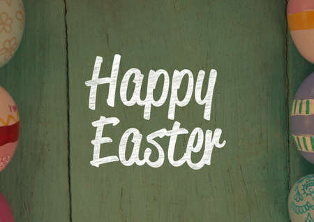 Happy easter text with easter eggs on green wooden background. easter holiday celebration concept...