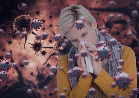 Composition of covid 19 cells over sick woman blowing her nose. global coronavirus pandemic and health concept digitally generated image.の写真素材
